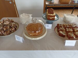 Photo of cakes laid out on a table, victoria sponge, rocky road, carrot cake etc
